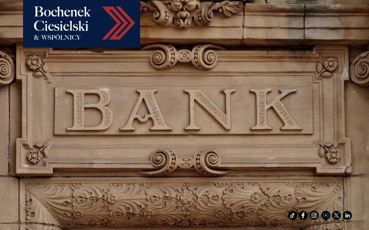 Zbliżenie na kamienny szyld z napisem BANK, symbolizujący instytucję finansową.