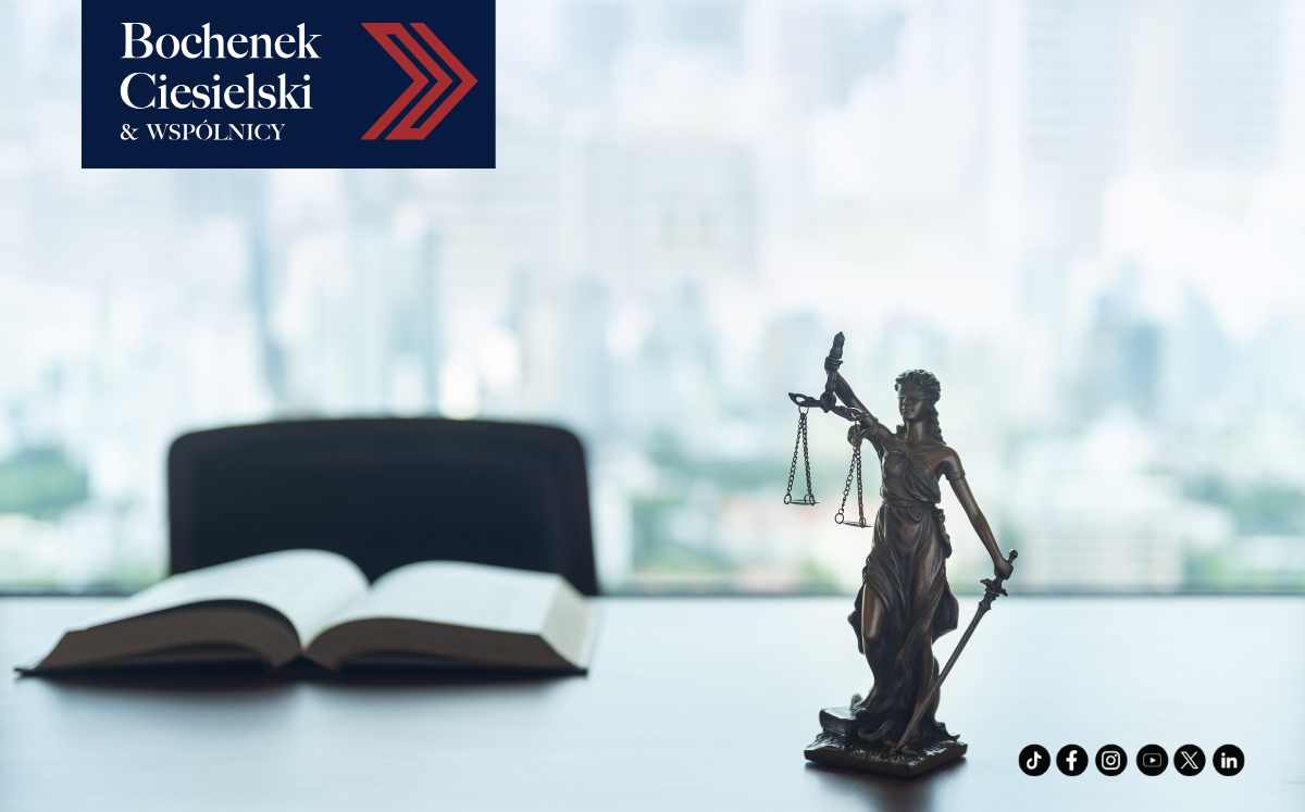 Figura Temidy i otwarta książka prawnicza na biurku w kancelarii Bochenek Ciesielski & Wspólnicy