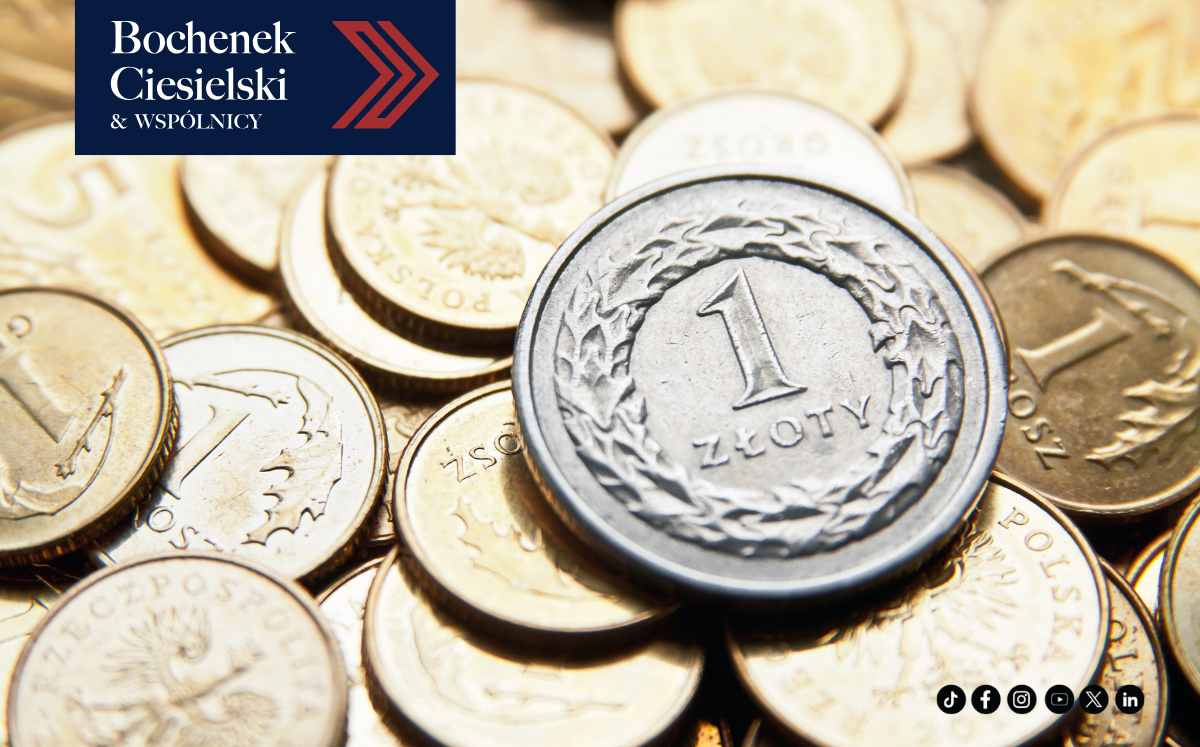 Stos monet polskich z widoczną monetą 1 złoty na pierwszym planie, logo kancelarii Bochenek Ciesielski & Wspólnicy w lewym górnym rogu.