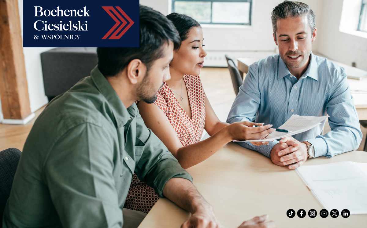 Prawnik omawiający dokumenty z parą klientów w nowoczesnym biurze – symbol wsparcia prawnego dla frankowiczów.