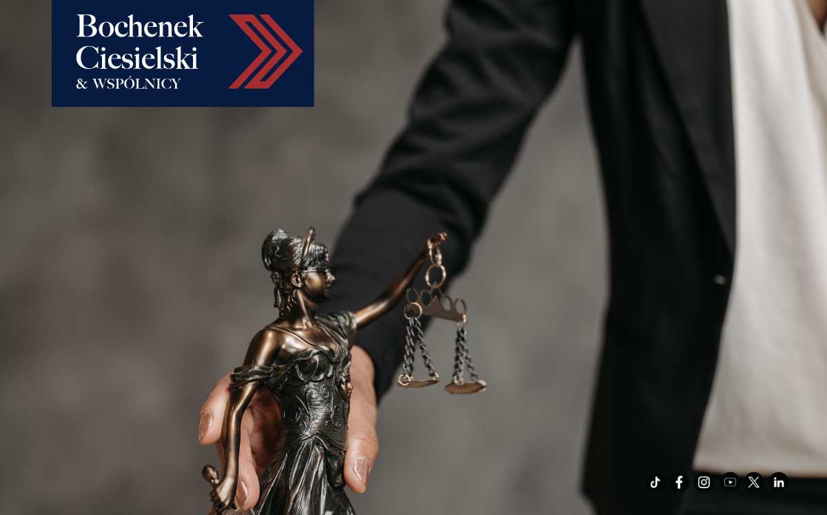 Prawnik w garniturze trzyma w dłoni figurkę Temidy symbolizującą sprawiedliwość. W lewym górnym rogu znajduje się logo kancelarii Bochenek Ciesielski & Wspólnicy.