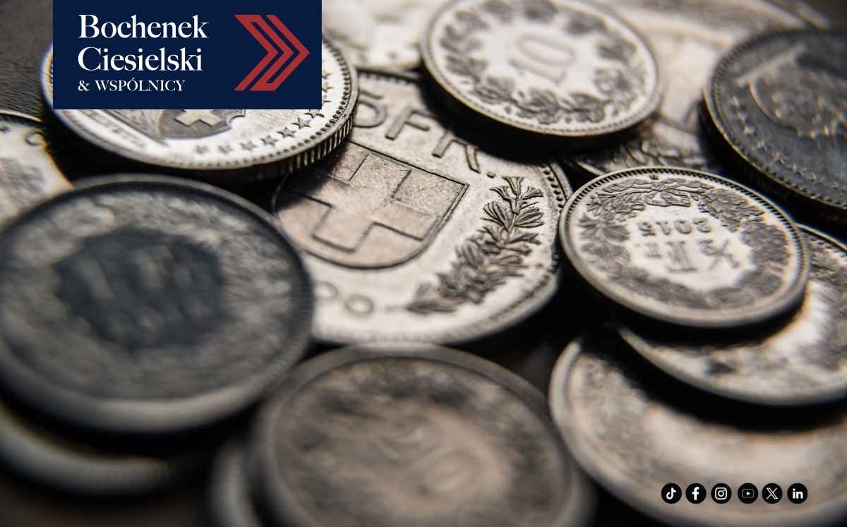 Zbliżenie na monety frankowe ułożone w stosie; w lewym górnym rogu znajduje się logo kancelarii Bochenek Ciesielski & Wspólnicy.