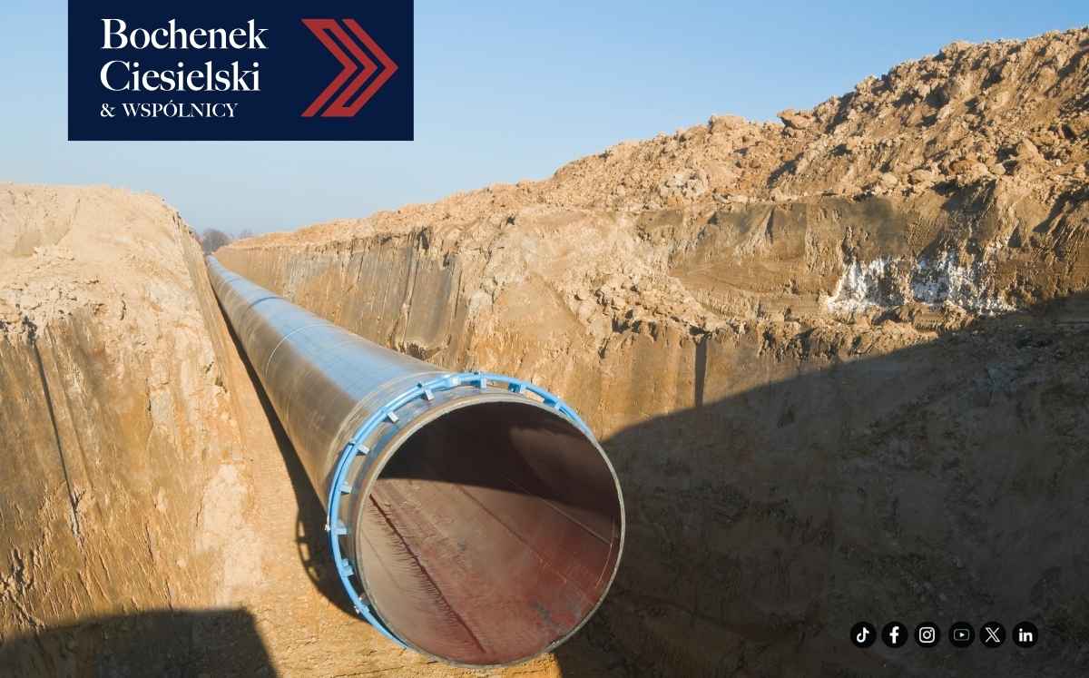 Prace ziemne przy budowie gazociągu – odkryty wykop i rurociąg przebiegający przez teren zielony.