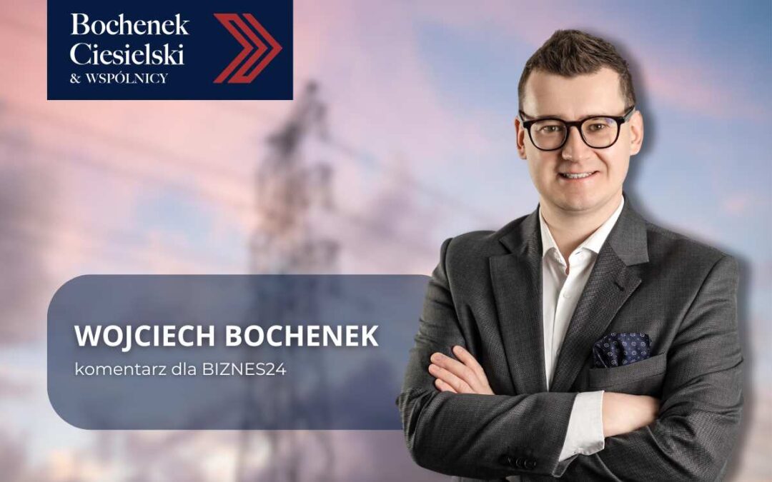 Mężczyzna w okularach i marynarce na tle nieba i słupa energetycznego; po lewej stronie tekst informacyjny oraz logo kancelarii Bochenek Ciesielski & Wspólnicy.