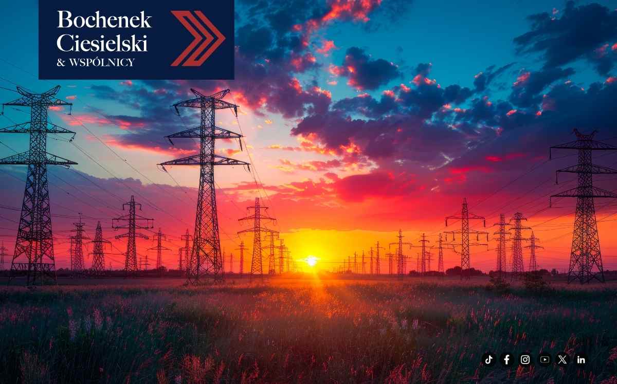 Linie i słupy wysokiego napięcia na tle zachodu słońca – infrastruktura energetyczna na terenach wiejskich
