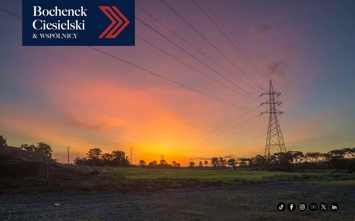 Słup energetyczny i linie przesyłowe na otwartym terenie o zachodzie słońca – infrastruktura energetyczna na działce
