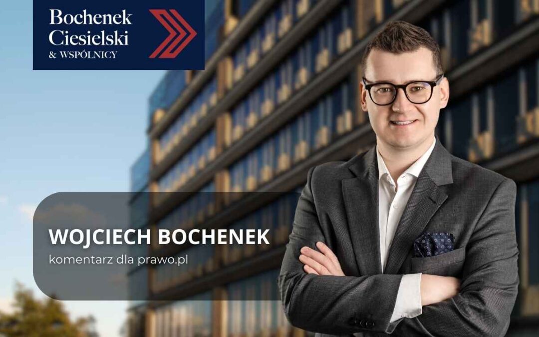 Wojciech Bochenek, prawnik kancelarii Bochenek Ciesielski & Wspólnicy, na tle nowoczesnego budynku biurowego.