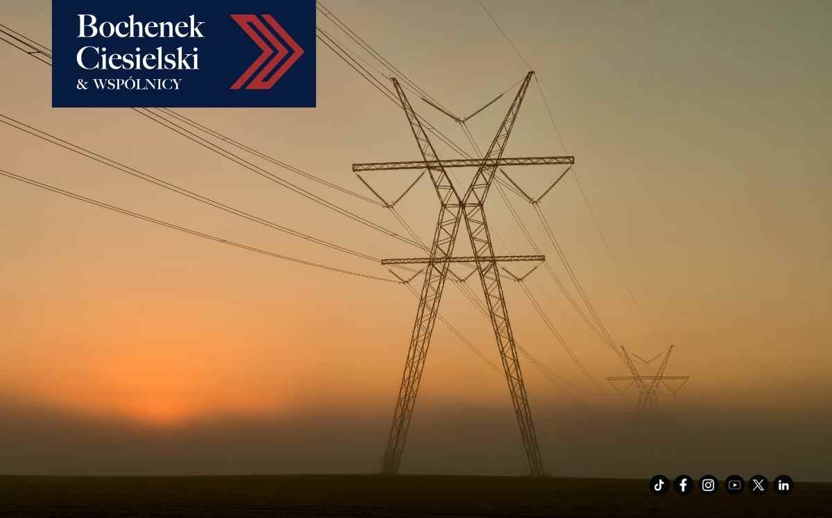 Linia energetyczna i słupy przesyłowe w krajobrazie o zachodzie słońca, symbol infrastruktury przesyłowej