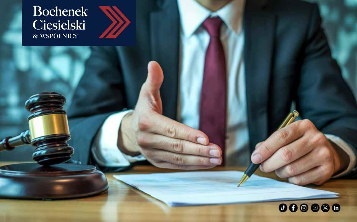 Prawnik podpisujący dokument przy biurku obok młotka sędziowskiego – symbol postępowania sądowego w sprawie frankowej.