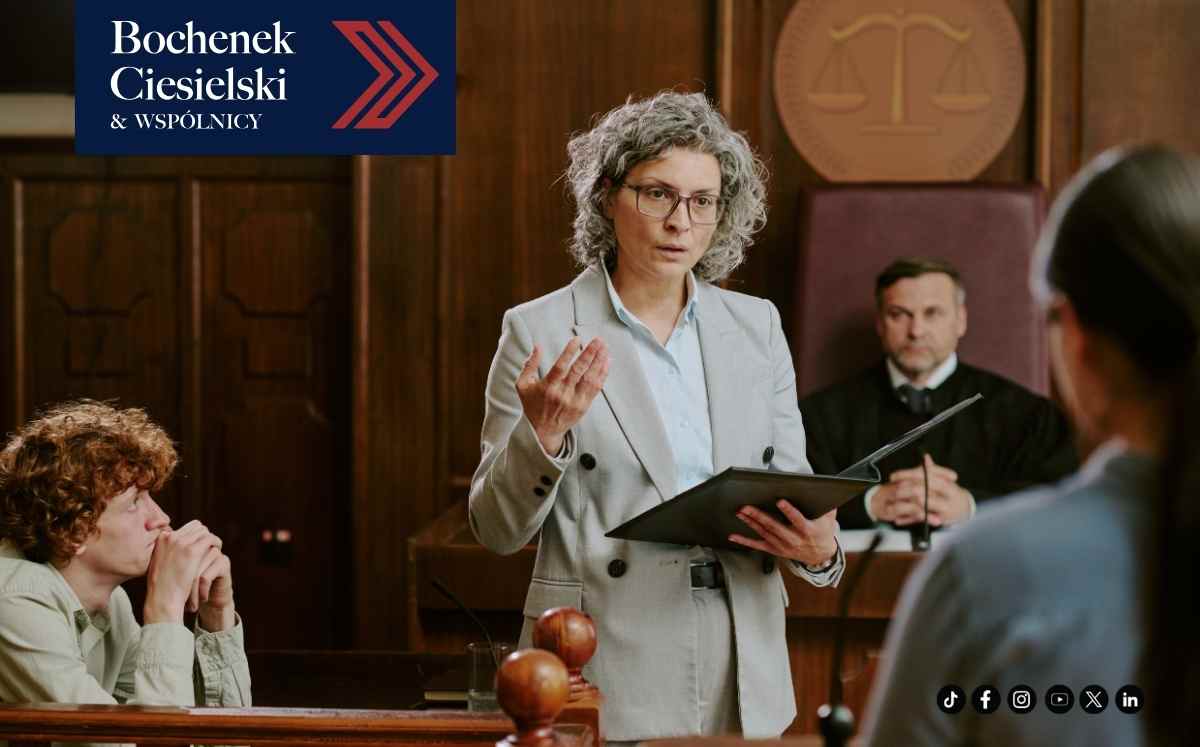 Prawniczka przemawia na sali sądowej, trzyma dokumenty; w tle sędzia i uczestnicy rozprawy, grafika kancelarii Bochenek Ciesielski & Wspólnicy.