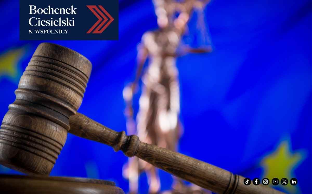 Drewniany młotek sędziowski na tle symbolu Temidy i flagi Unii Europejskiej; w lewym górnym rogu logo kancelarii.