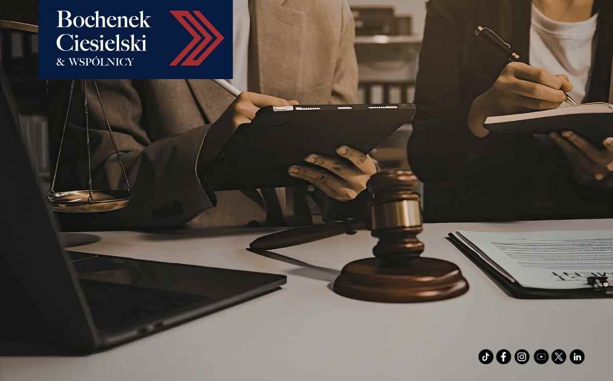 Prawnicy analizujący dokumenty przy biurku z laptopem i młotkiem sędziowskim w kancelarii