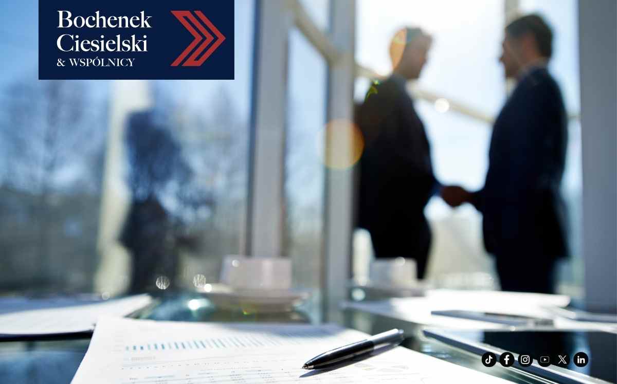 Logo kancelarii Bochenek Ciesielski i Wspólnicy na tle spotkania biznesowego i dokumentów leżących na biurku.