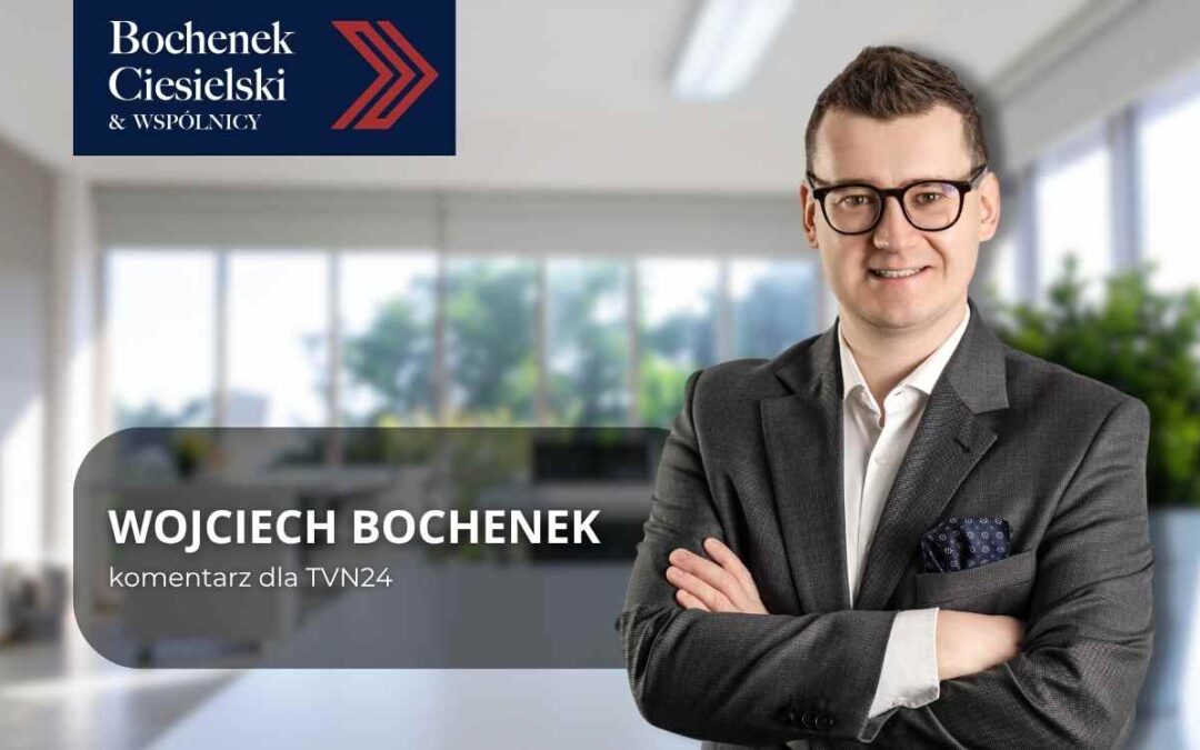 Portret prawnika Wojciecha Bochenka w garniturze, stojącego z założonymi rękami w biurze; podpis: komentarz dla TVN24, kancelaria Bochenek Ciesielski & Wspólnicy.