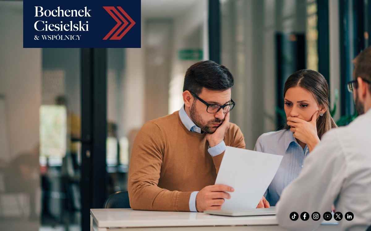 Para klientów analizująca dokumenty związane z dochodzeniem roszczeń po śmierci bliskiej osoby w kancelarii