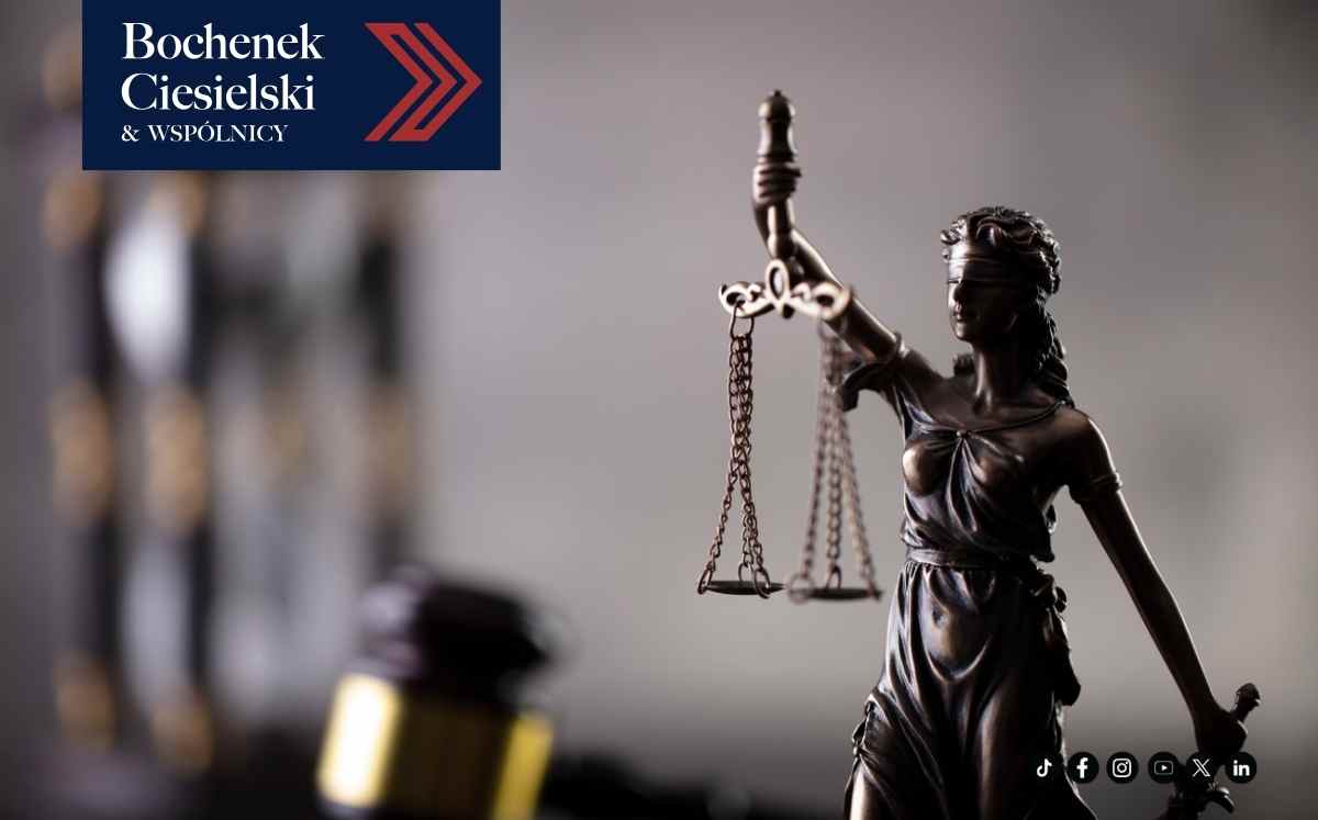 Statua Temidy z wagą w dłoni na tle rozmytego wnętrza, symbol prawa, sprawiedliwości i bezstronności.