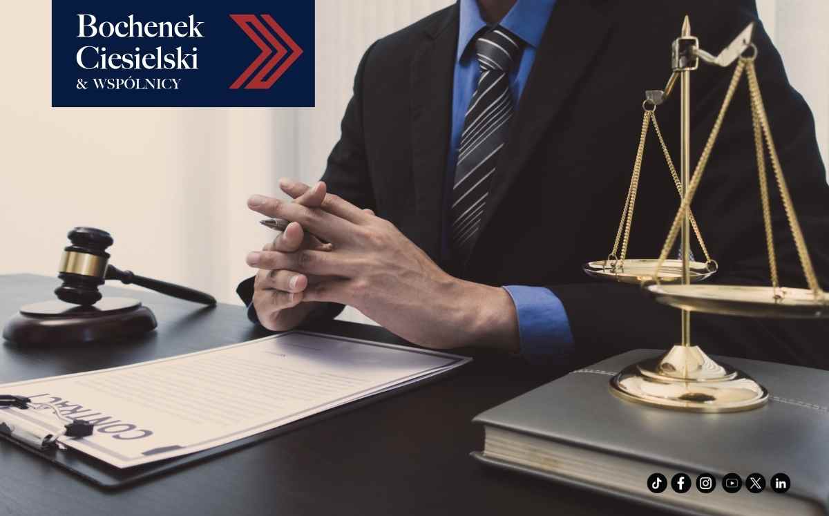 Prawnik przy biurku z wagą sprawiedliwości i młotkiem sędziowskim, grafika kancelarii Bochenek Ciesielski & Wspólnicy.