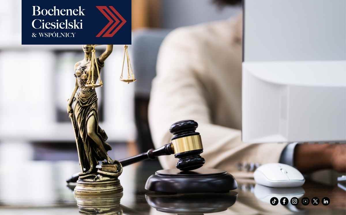 Statuetka Temidy i młotek sędziowski na biurku prawnika, symbol prawa i sprawiedliwości.”