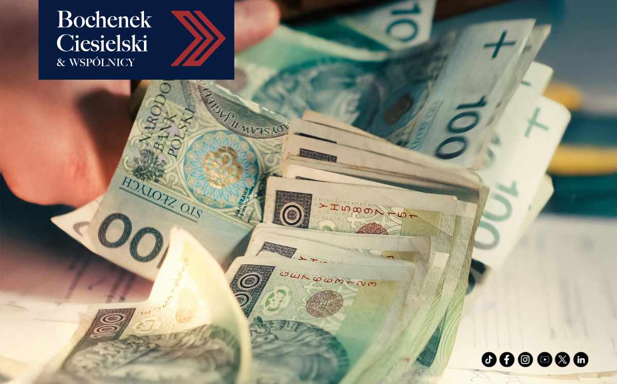 Polish zloty banknotes spread on a desk with Bochenek Ciesielski & Wspólnicy branding in the top-left corner, suggesting financial legal services.