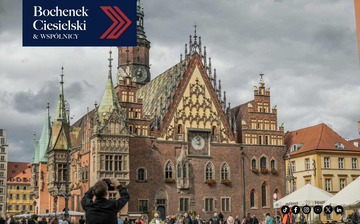 Historyczny ceglany ratusz we Wrocławiu z ludźmi robiącymi zdjęcia na rynku