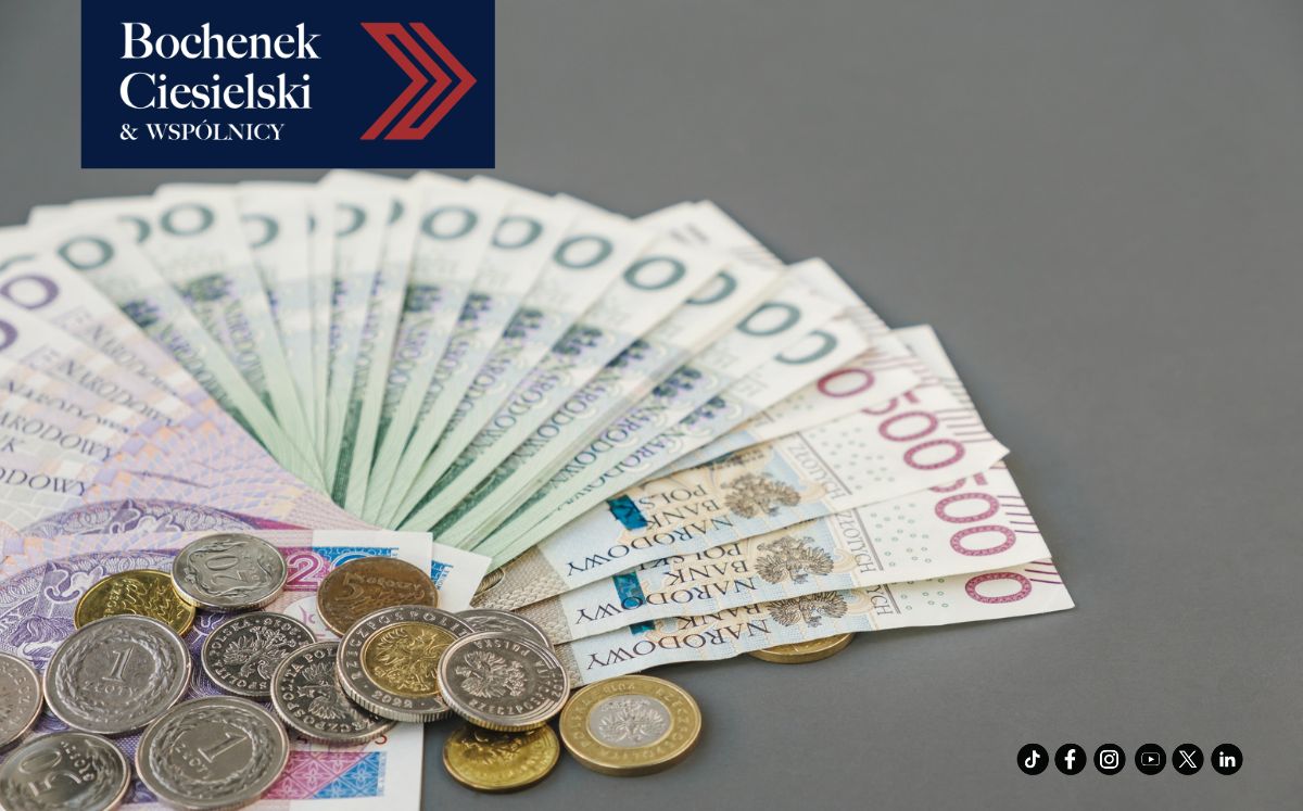 Wachlarz z banknotów o nominale 500 zł oraz stos monet na jednolitym tle
